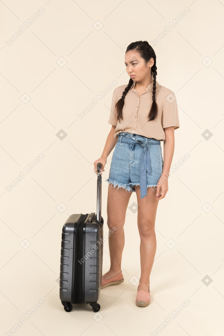 가방 근처에 서 걱정 된 젊은 여자