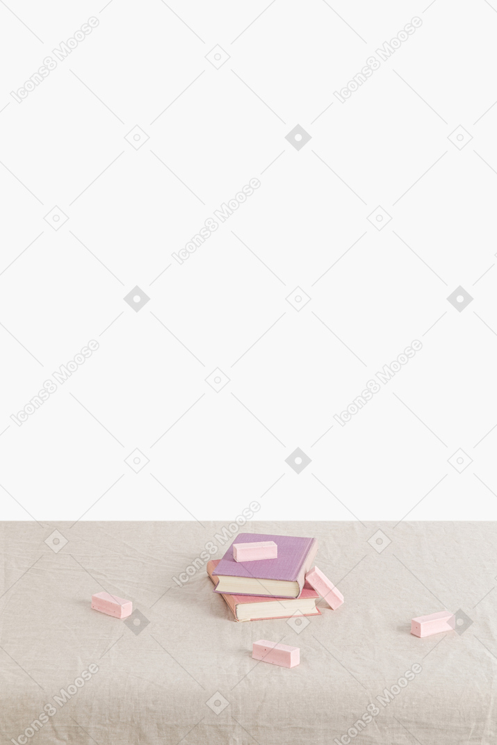Books and scattered marshmallows on a canvas tablecloth