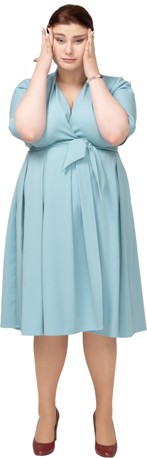 Vista frontale di una donna in abito blu che tocca la testa