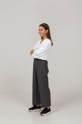 Three-quarter view of a smiling young lady in office clothing looking aside