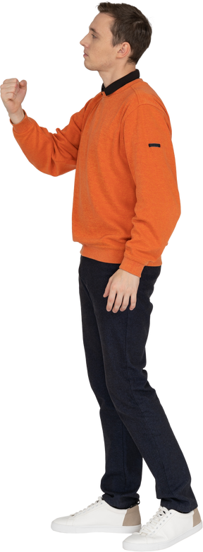 オレンジ色のスウェットシャツに立っている若い男