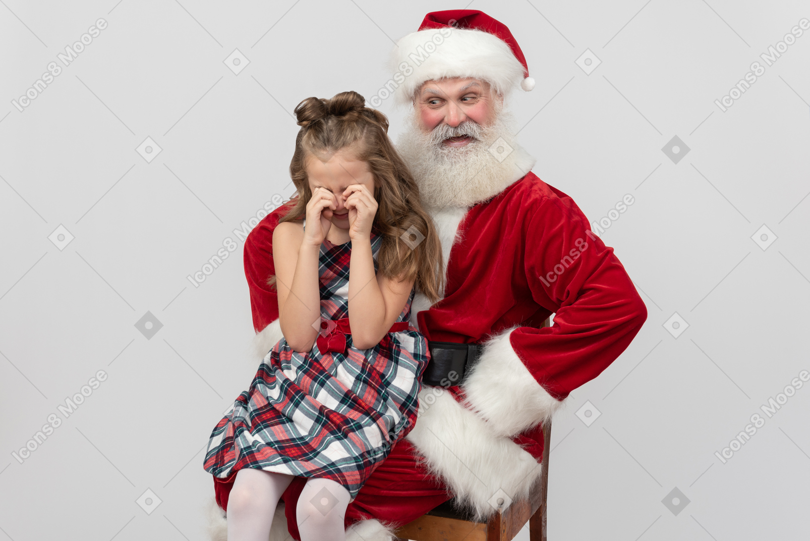 Ragazza ragazzina seduta sulle ginocchia di babbo natale e piangendo