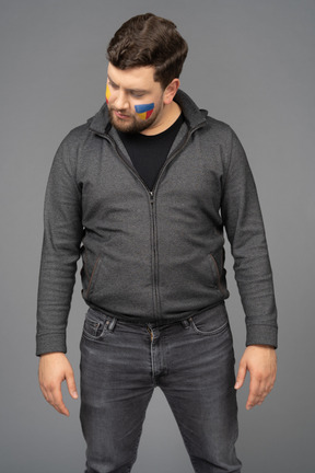 Front view of a frustrating male football fan with colorful face art