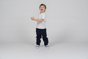 Little boy standing and moving his arms around