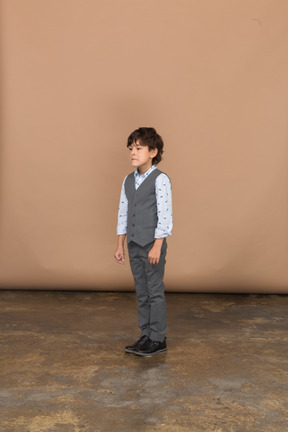 Vista frontale di un ragazzo vestito in piedi con i pugni chiusi