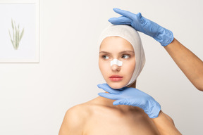 Female patient with gloved hands above and below her face