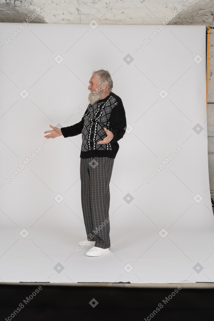 Вид сбоку веселого пожилого мужчины, стоящего с распростертыми объятиями