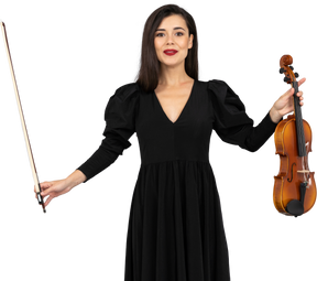 Vista frontal de uma violinista vestida de preto fazendo uma reverência