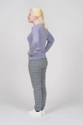 Joyful young woman standing with her hands on her hips