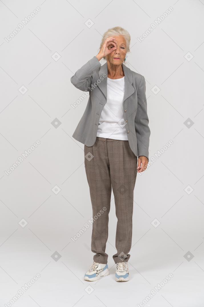 손가락을 통해 보는 양복에 있는 노부인의 전면 보기