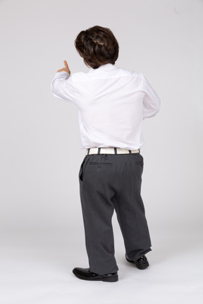 Back view of man in white shirt pointing away
