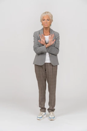 Front view of an old lady in suit showing stop sign