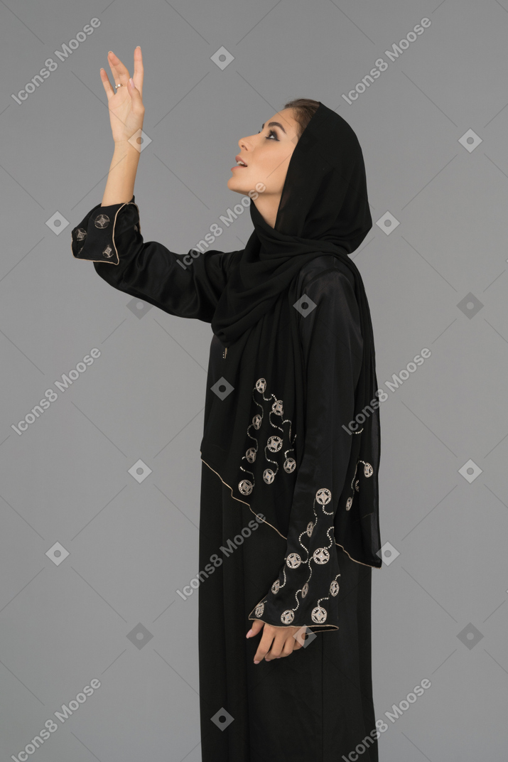 Muslim woman pointing upwards