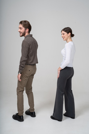 Side view of a laughing young couple in office clothing