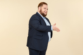 Young overweight man in suit giving a hand