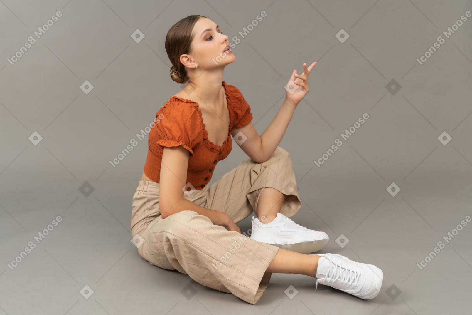 Young woman sits with raised hand