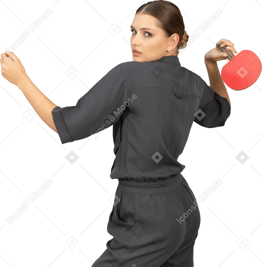 Vista posteriore di tre quarti di una giovane donna in tuta che gioca a ping pong