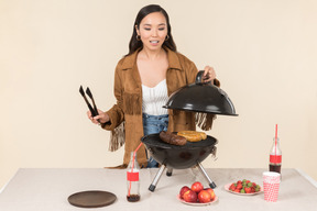 Jeune femme asiatique fait et sentant le barbecue