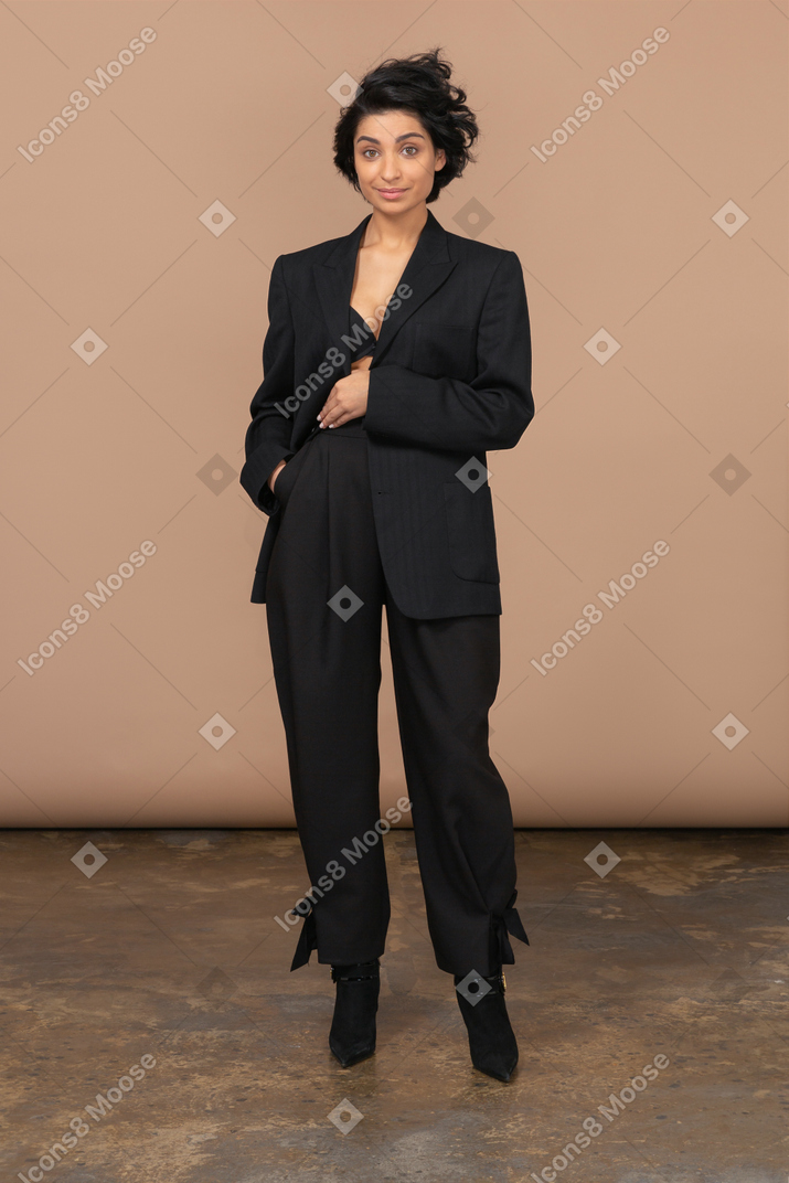 Vue de face d'un costume noir de femme d'affaires regardant gaiement la caméra