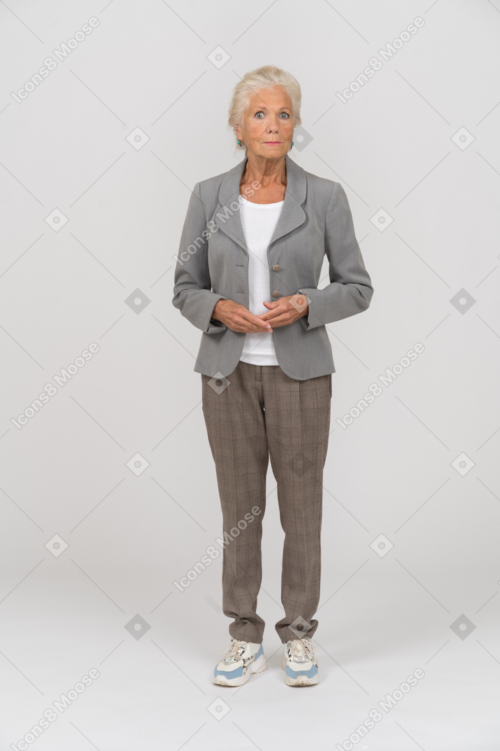 Vue de face d'une vieille femme en costume regardant la caméra