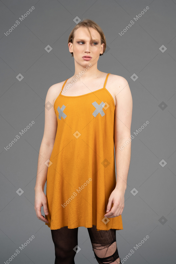 Porträt einer jungen nicht-binären person, die ein orangefarbenes kleid trägt