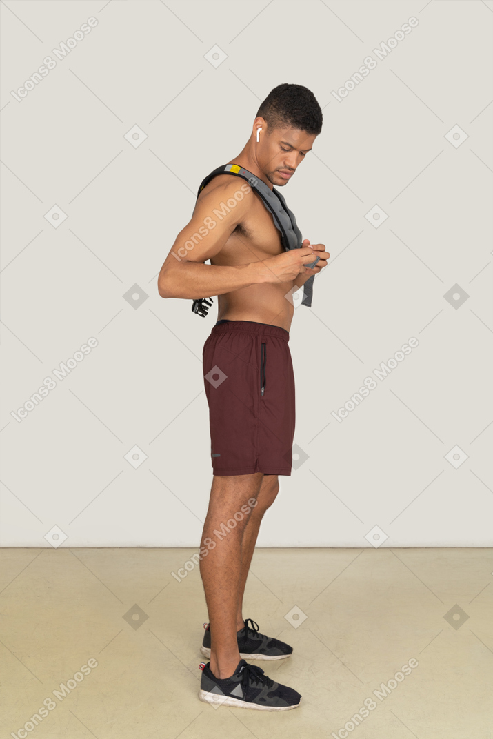 Seitenansicht eines muskulösen mannes, der die gewichtsweste anpasst