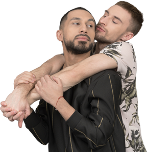 A man is hugging his boyfriend from behind