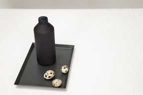 Schwarze vase und wachteleier auf dem schwarzen tablett