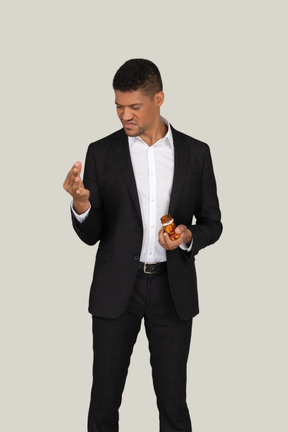 African american man in black suit holding at pills he's holding