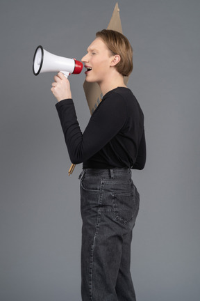 Side view of shouting person with megaphone and sign in hand