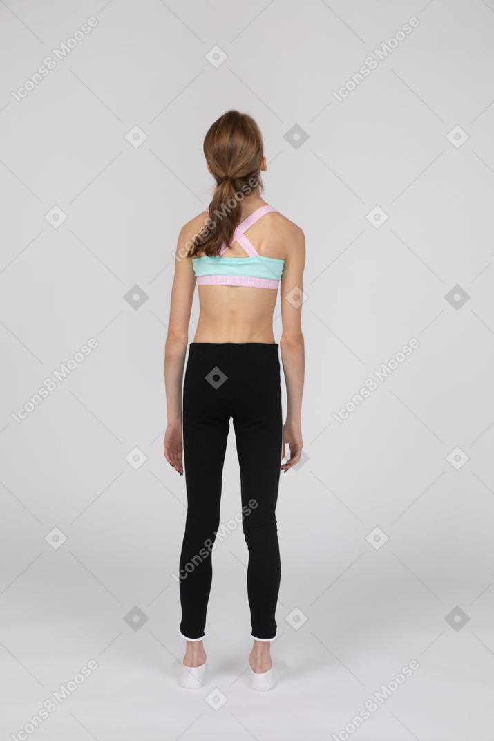 Vista traseira de uma adolescente em roupas esportivas jogando a cabeça para trás