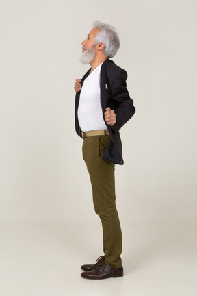 Side view of a man taking off his jacket