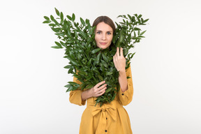 Young woman sticking face out of branches