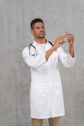 Male doctor preparing a syringe