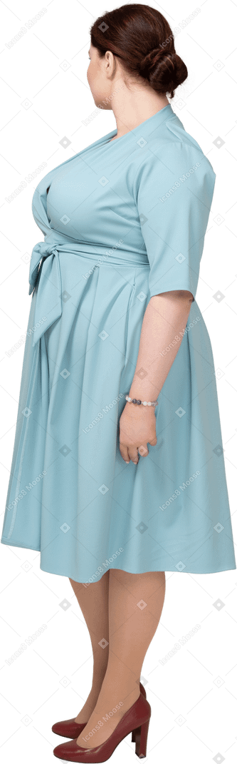 Woman in blue dress standing in profile