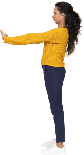Vista lateral de uma garota com roupas casuais mostrando um gesto de pare