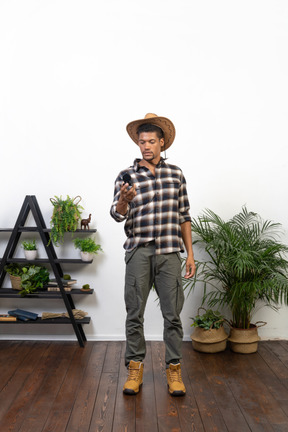 Front view of a tourist in a cowboy hat examining the compass