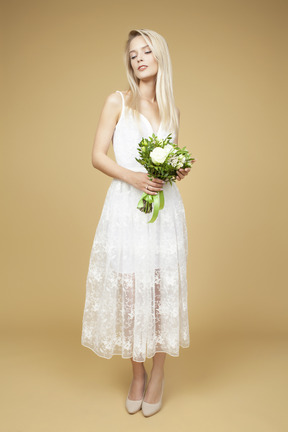 Красивая молодая невеста держит букет белых цветов