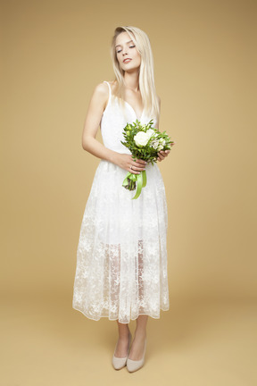 Beautiful young bride holding bouquet of white flowers