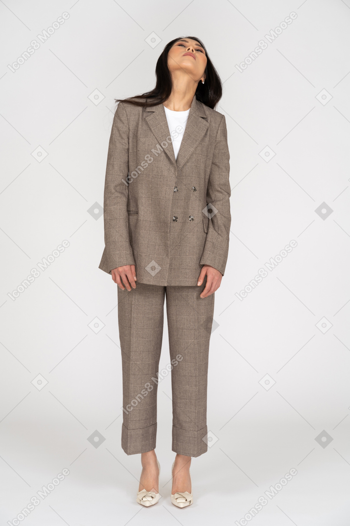 Front view of a young lady in brown business suit raising her head