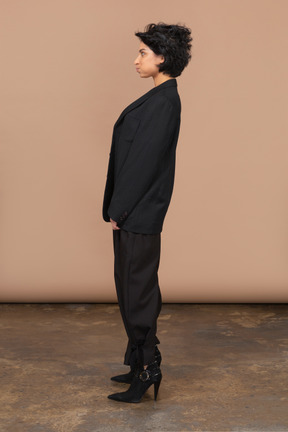 Side view of a businesswoman in a black suit pouting and looking aside