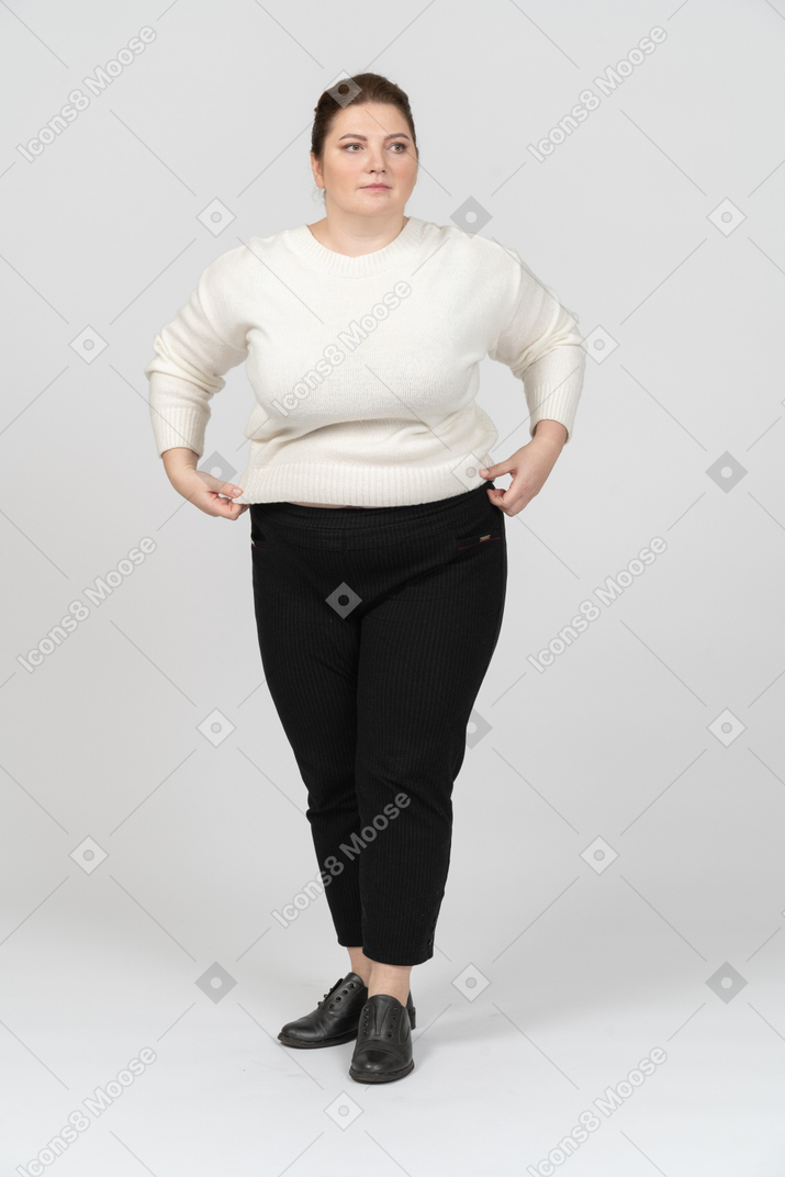白いセーターのポーズでプラスのサイズの女性