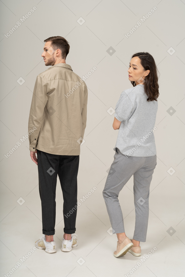 Young couple looking over shoulders