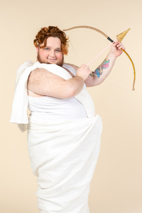 Big guy dressed as a cupid holding bow and arrow