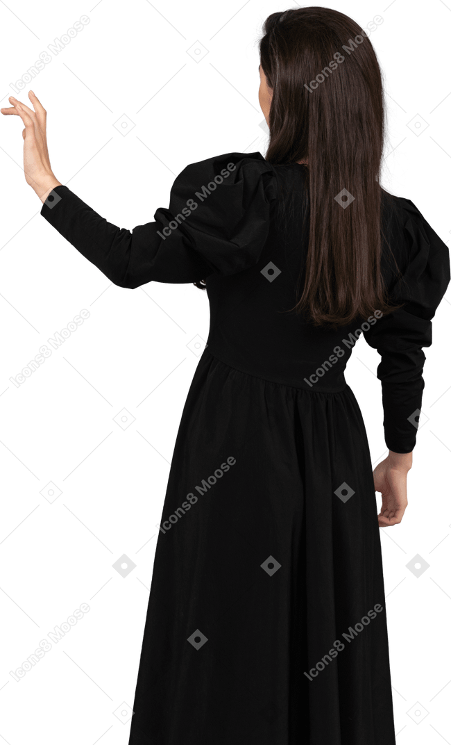 Vista posteriore di una giovane donna in un abito nero, alzando la mano