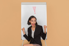 Attractive afro woman sitting by the whiteboard