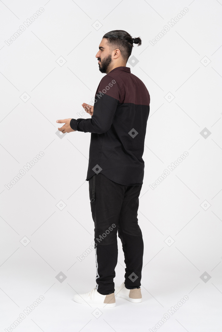 Confused young man spreading arms