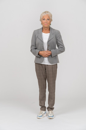 Front view of an old woman in suit looking at camera