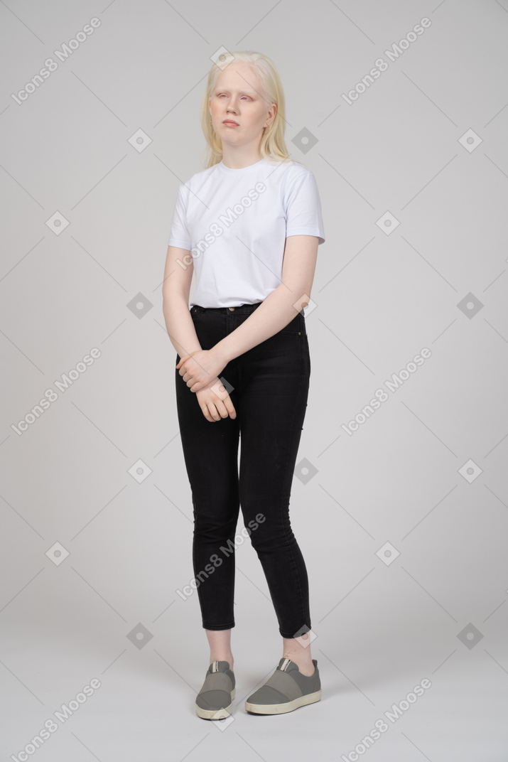Front view of a young blonde woman in casual clothes looking aside
