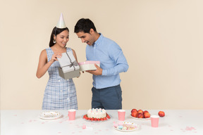 Young asian woman giving presents to a caucasian guy